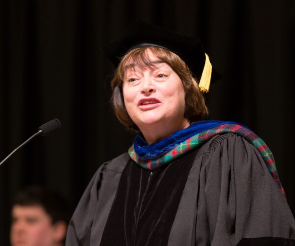 Lisa Bullard dressed in graduation robes giving commencement address