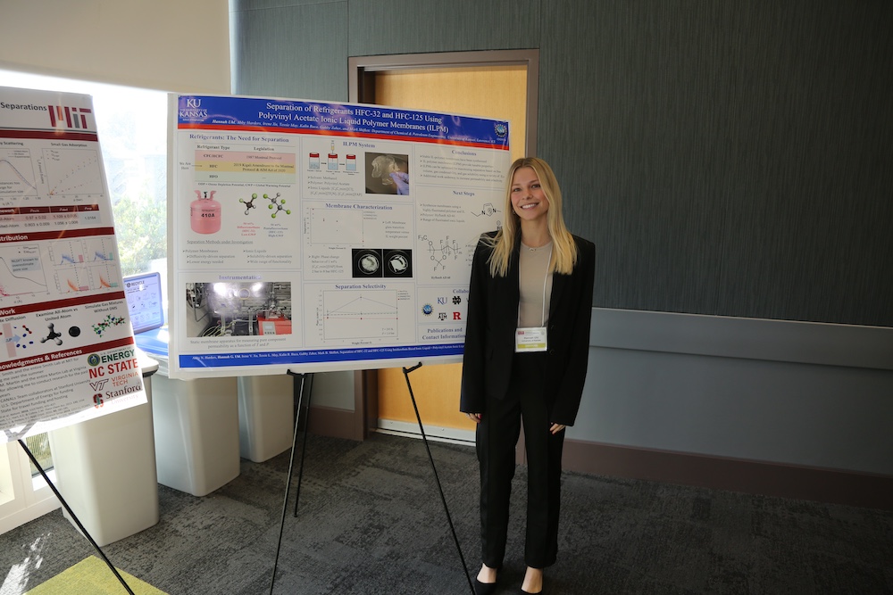 woman poses with her research poster