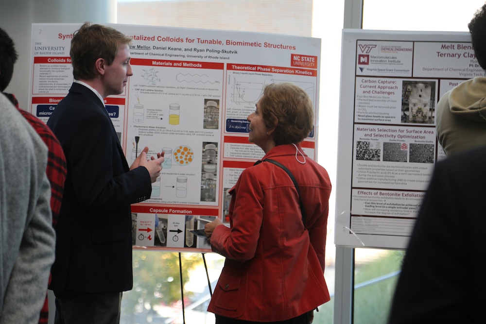 candid photo of a man explaining his research poster