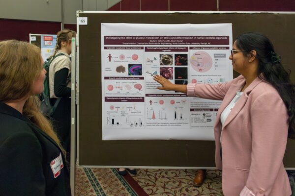 two women in front of research poster