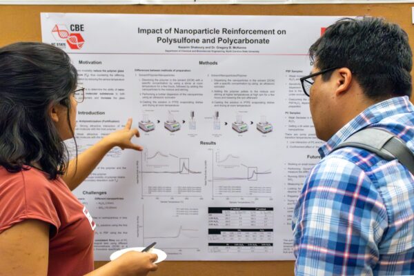 man and woman stand in front of research poster